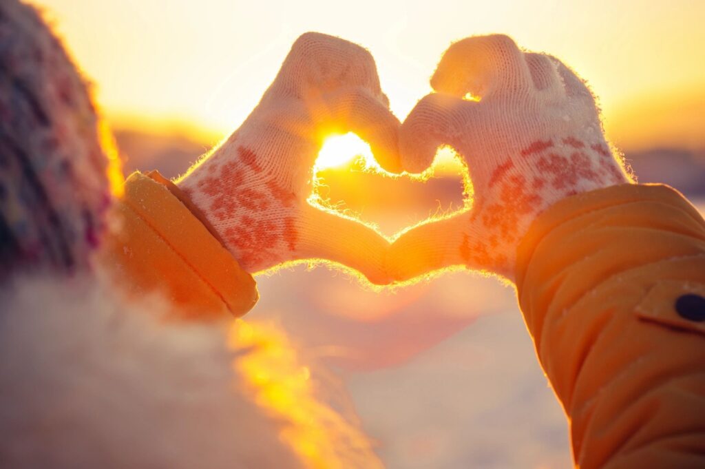heart hands into sunset in winter